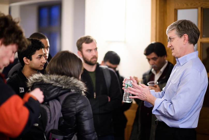 Photo of Professor Ed Felten speaking with students following his presentation. 