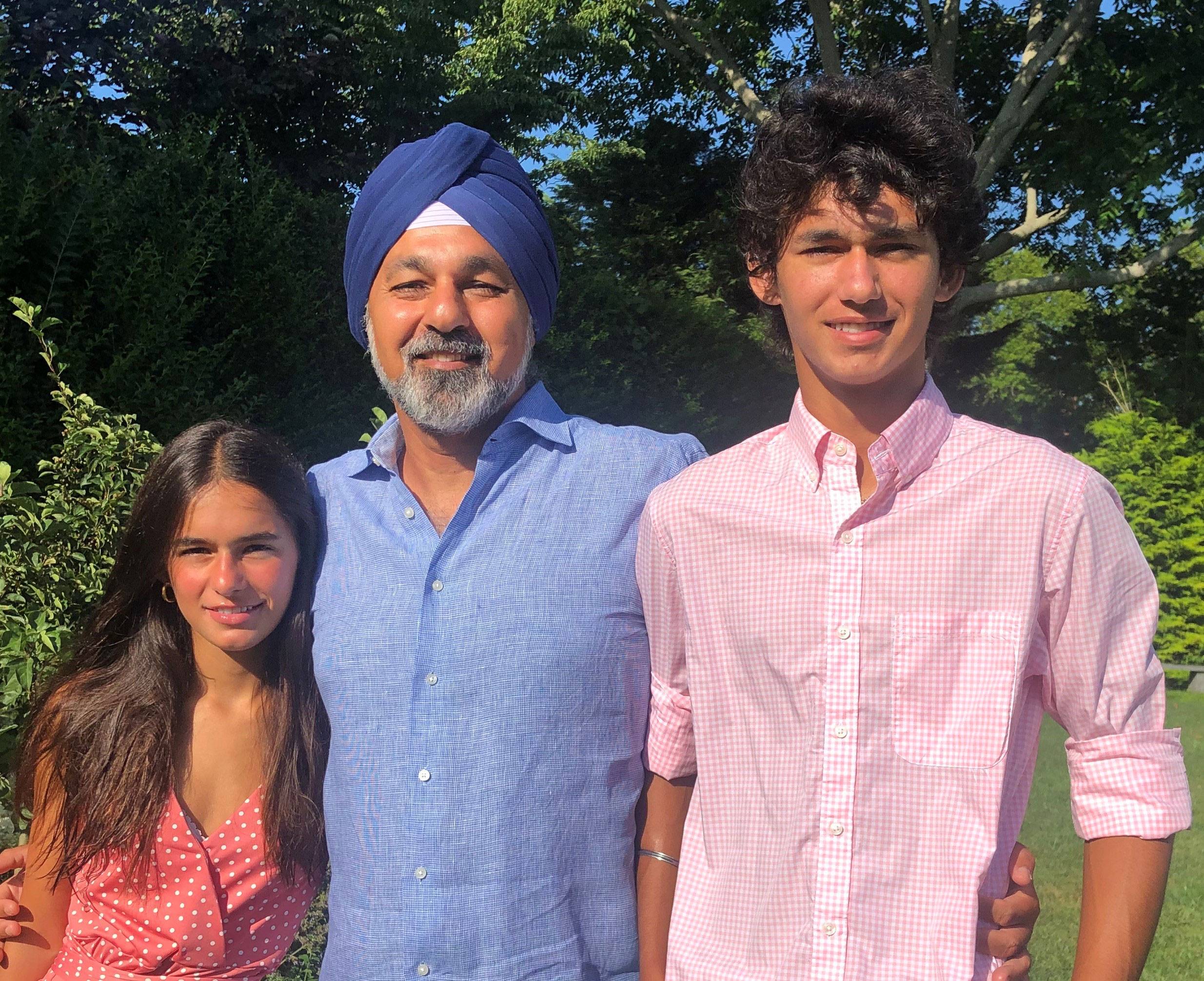 Photo of Jaswinder Pal (JP) Singh with his children, Sophia and Kabir standing outside in front of trees.