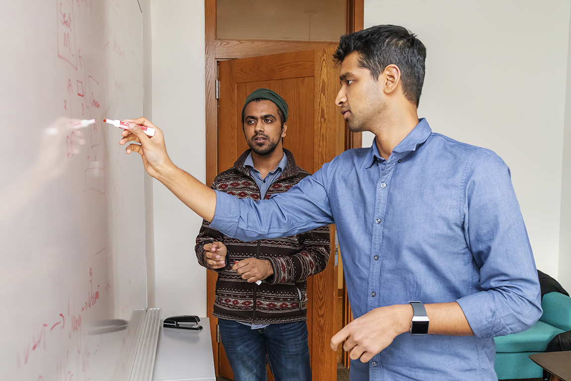 Karthik Narasimhan standing at a white board with undergraduate student Karan Arora, C.S. class of 2019.