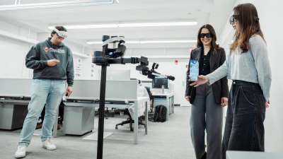 Three researchers standing around a robot wearing mixed reality headsets