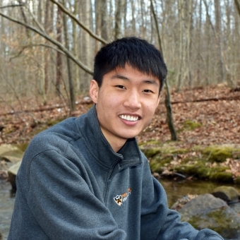 Photo of Charles Zhao outside in the woods.