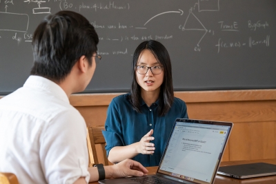 Danqi Chen speaking with Zexuan Zhong, CS graduate student.