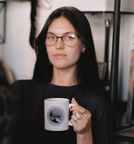 Photo of Rose Guingrich holding a coffee mug.