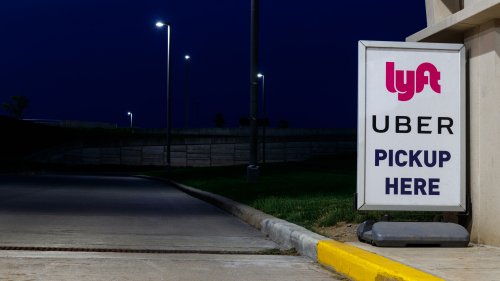 Lyft Uber pick up here sign at a curb
