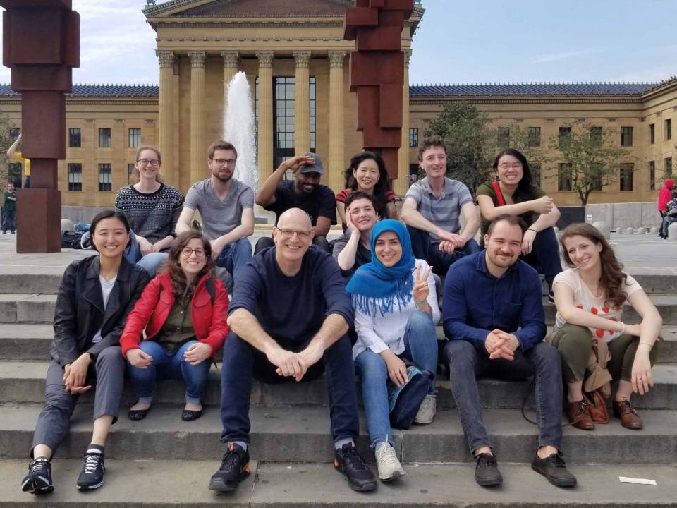 Lab group sitting on the steps in front of a large building with columns in Philadelphia.